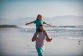 Little boy kid with daddy carrying him on shoulders. Father giving son ride on back outside. Concept of friendly family Royalty Free Stock Photo