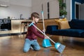 Little boy kid doing daily regular household chores sweeping floor in living room Royalty Free Stock Photo