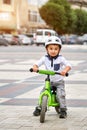 Little boy kid in helmet ride a bike in city park. Cheerful child outdoor. Royalty Free Stock Photo