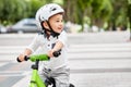 Little boy kid in helmet ride a bike in city park. Cheerful child outdoor. Royalty Free Stock Photo