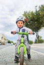 Little boy kid in helmet ride a bike in city park. Cheerful child outdoor.