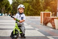 Little boy kid in helmet ride a bike in city park. Cheerful child outdoor. Royalty Free Stock Photo