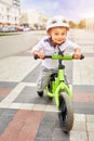 Little boy kid in helmet ride a bike in city park. Cheerful child outdoor. Royalty Free Stock Photo