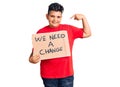 Little boy kid holding we need a change banner pointing finger to one self smiling happy and proud
