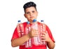 Little boy kid holding recycling plastic bottles thinking attitude and sober expression looking self confident Royalty Free Stock Photo
