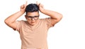Little boy kid wearing casual clothes and glasses doing funny gesture with finger over head as bull horns Royalty Free Stock Photo