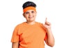 Little boy kid wearing sportswear with a big smile on face, pointing with hand finger to the side looking at the camera Royalty Free Stock Photo