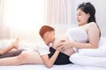 Little boy Kissing the belly of the pregnant mother. Pregnant mother and son are happy. Royalty Free Stock Photo