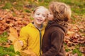 Little boy kissing a girl in autumn park. Kids love concept.