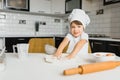 Little boy in kitchen.Cute boy wears a chef hat and apron