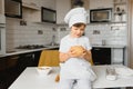 Little boy in kitchen.Cute boy wears a chef hat and apron