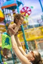 Little boy laughing with his mom at an outdoor water park during summer vacation Royalty Free Stock Photo