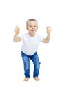 A little boy laughs and jumps with his arms outstretched funny. Child in a white T-shirt and jeans. Activity and energy. Isolated Royalty Free Stock Photo