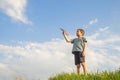 Little boy launches a paper plane into the air. Child launches a paper plane. Happy kid playing with paper airplane Royalty Free Stock Photo