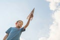 Little boy launches a paper plane into the air. Child launches a paper plane. Happy kid playing with paper airplane Royalty Free Stock Photo