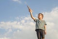 Little boy launches a paper plane into the air. Child launches a paper plane. Happy kid playing with paper airplane Royalty Free Stock Photo