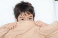 Little boy lay on bed with blanket cover half face Royalty Free Stock Photo