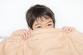 Little boy lay on bed with blanket cover half face Royalty Free Stock Photo