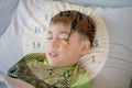 Little boy laying down on the bed with clock exporsure Royalty Free Stock Photo