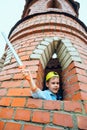 little boy leans out of the window and waving a toy sword. Royalty Free Stock Photo