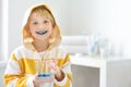 Little boy is learning carefully brush teeth. Child using liquid for disclosing plaque. Teaching children proper oral hygiene.