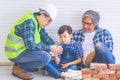 Little boy learning how to build brick wall from his construction Multi generation family