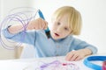 Little boy learning make model with 3d printing pen. Child playing with new modern toy for creativity. DIY Royalty Free Stock Photo