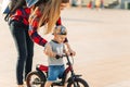 Boy is learning to ride a bike with his Mom in the park. Happy mom teaches son to ride a bike Royalty Free Stock Photo