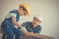 Little Boy learning to work on wood and be a builder from his craftman father in vintage tone