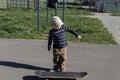 A little boy learns extreme sports, skateboarding in the summer on the playground, in the park and outdoors