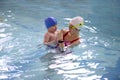 Little boy learns to swim in an individual lesson with a trainer Royalty Free Stock Photo