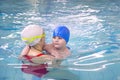 Little boy learns to swim in an individual lesson with a trainer Royalty Free Stock Photo