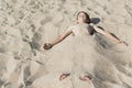 A little boy on the beach buried in the sand Royalty Free Stock Photo