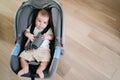 a little boy lies strapped in a stroller-carrier.