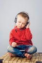 Little boy listening to music with smartphone.