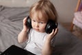 little boy listens music in headphones on his head.looks up. shooting in the studio on a gray background Royalty Free Stock Photo