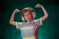 Little boy listens to his favorite music in modern wireless headphones, in the studio Royalty Free Stock Photo