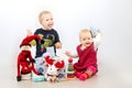 Little boy and little girl playing with Christmas gifts and toys isolated over white background. Royalty Free Stock Photo