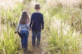 Little boy and little girl standing holding hands looking on horizont. Rear view. Royalty Free Stock Photo
