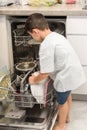 Son helping father with the dishwasher. Chores concept. Royalty Free Stock Photo