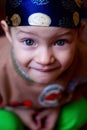 Little boy looking at the camera, blue eyes bright in the bandana