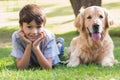 Little boy looking at camera with his dog in the park Royalty Free Stock Photo