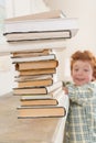 Little boy looking at pile of books, focus on foreground