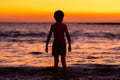 Little boy looking at sunset at the ocean and preparing to swim Royalty Free Stock Photo