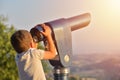Little boy looking into tourist telescope eyepiece. Travel tourist destination landscape magnification