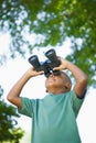 Little boy looking up through binoculars in the park Royalty Free Stock Photo