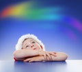 Little boy looking up to rainbow on sky