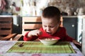 The little boy looks at the camera while eating breakfast. Royalty Free Stock Photo