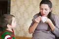 The little boy looks at a sick pregnant mother. Pregnant young woman with nosebleed. Severe pregnancy concept Royalty Free Stock Photo