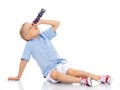 A little boy looks through a telescope or kaleidoscope.